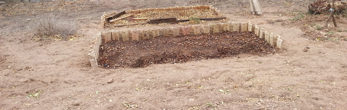 The raised bed made with roof tiles is read with soil full of organic matter